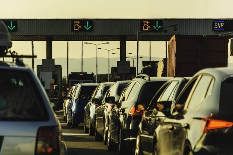 Cars and trucks waiting at point of toll highway-cm